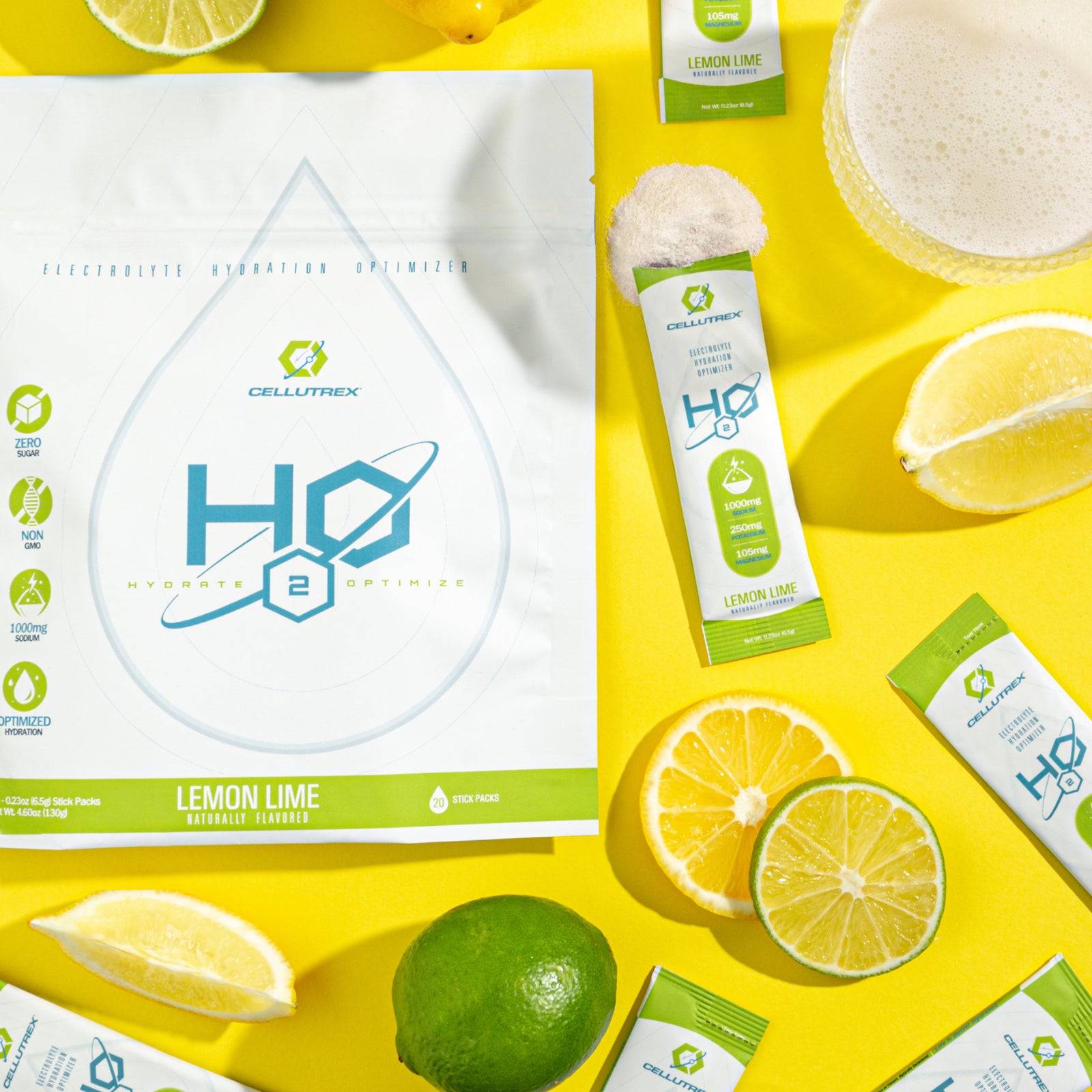 H2O Electrolytes™ Lemon Lime zero sugar electrolyte powder with fresh lemon and lime slices, powder mix, and a refreshing fizzy drink on a bright yellow background. Sugar-free hydration mix for daily wellness and endurance.
